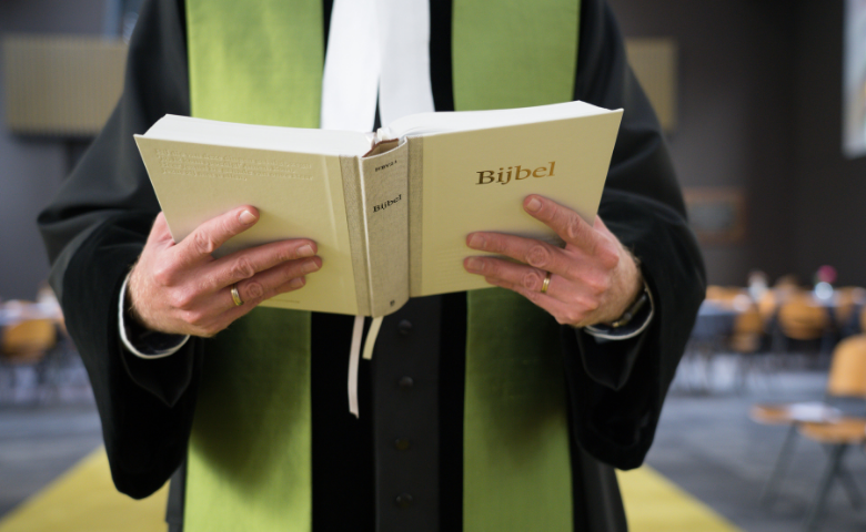 Dominee met de NBV21 in de kerk