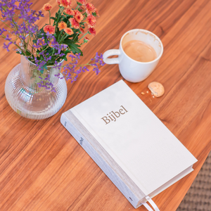 NBV21 op een tafel met een kopje koffie en bloemen